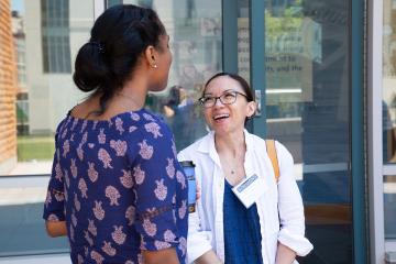 A Simmons Public Health student laughing while in conversation with another student