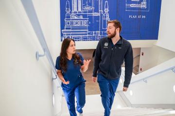 Two Simmons graduate nursing students talking as they climb a set of stairs