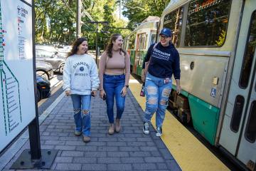 Three Simmons students at a Boston T station