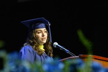 A student speaker at the podium during the 2026 Commencement Ceremony. Photo credit: Ivana Lucero, Grad Images