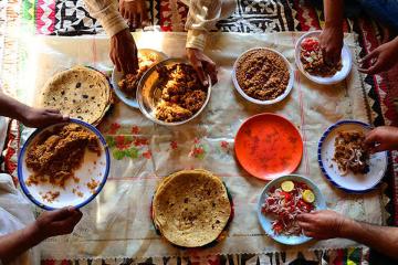 A collection of Pakistani food being shared by a number of people