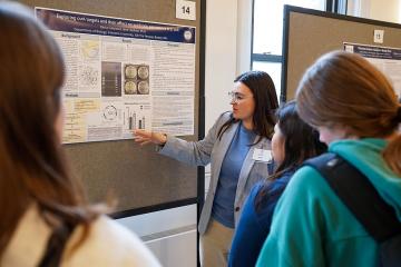 A student presents her work to a crowd at the 2026 STEM Colloquium