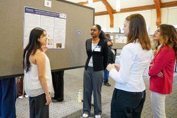 A student discusses her poster at the 2026 STEM Colloquium