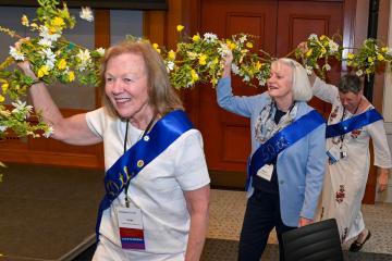 Members of the class of 1976 carrying a flower chain during Reunion 2026