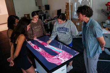 Students learning to use an anatomage table at Simmons University