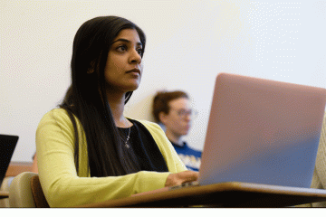 Student sitting at a computer during a seminar.