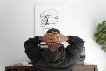 man in gray hoodie sitting on chair - Photo by Keenan Beasley