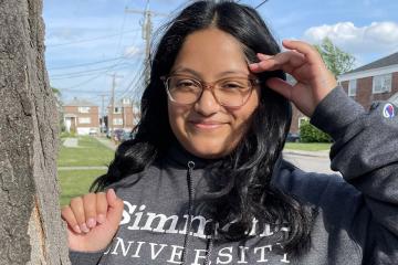 Phot of Marina McCollum in Simmons sweatshirt outside by tree