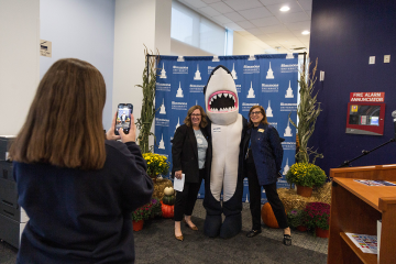 Stormy, the Simmons mascot, posing for pictures during Alumnae, Family, and Friends Weekend 2023