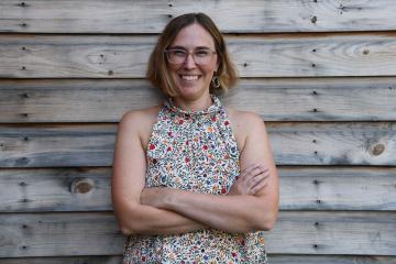 Emily Ostrow ’09MSW leaning against a wall and smiling