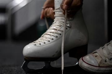 A person lacing up an ice skate