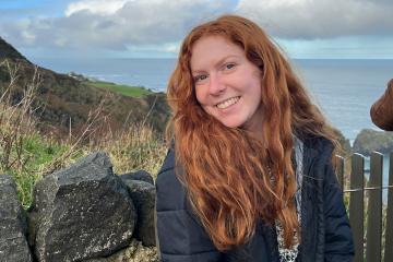 Gracyn Delaune ’24 poses with the coastline of Ireland in the background