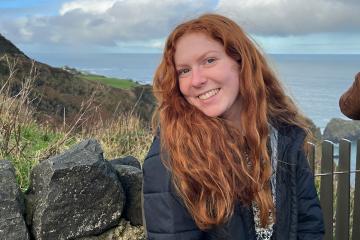 Gracyn Delaune ’24 poses with the coastline of Ireland in the background