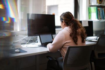 student at desk using laptop