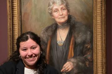 Helena Saldivar-Mieres poses in front of a portrait of British suffragette Emmeline Pankhurst (1858–1928).