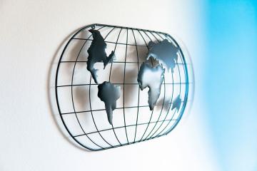 A representation of the globe made into a metal wall hanging. Photo by George Bakos on Unsplash.