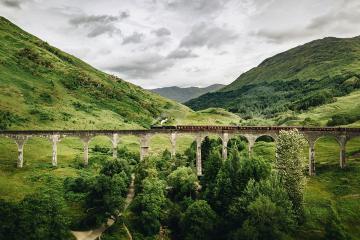 A train going over a long elevated bridge in Scotland. Photo by Bjorn Snelders on Unsplash.