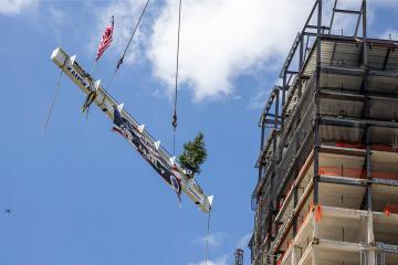 The final beam for the LCC project is hoisted during the Topping Off Ceremony