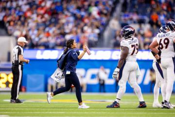 Alexia Malone Oliver running onto the field during an NFL game