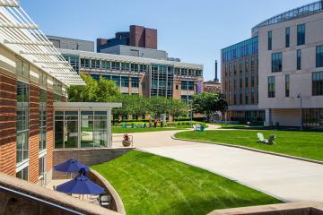 Photo of main campus quad on a bright sunny day. the view is looking from the Fens towards Drinan Hall and Palace Road