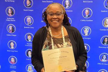Simmons Nursing Professor LaDonna Christian holds her certificate from her induction into the American Academy of Nursing