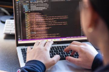 A computer science student using their laptop to write code