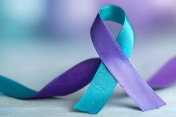 The purple and teal ribbon, a symbol of solidarity with survivors of domestic violence and sexual violence.