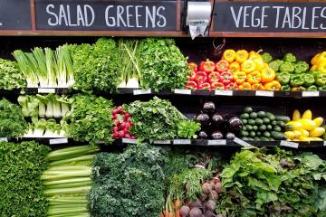 A selectioon of salad greens and vegetables on display in a grocery store