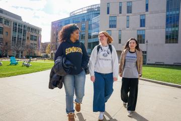 Three undergraduate students walking on the campus of Simmons University