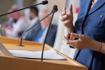 A close-up of a speaker's hands while the speaker is standing at a podium