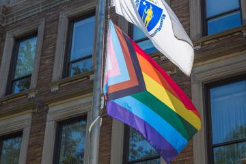 A pride flag being flown on the Simmons campus. Campus photograph by Kate Smith.