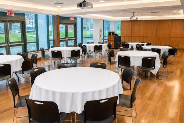 The Kotzen Room set up for a banquet with round tables and a view of the large windows