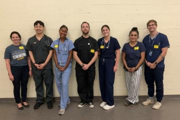 Tina Delouchry and Delmy Piano with a group of graduate nursing students who gained experience giving physical exams to middle and high school student athletes.