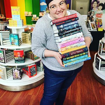 Christina Pascucci-Ciampa holding a stack of great books