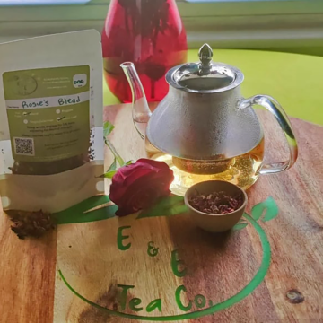 A bag of Rosie's Blend tea on a table next to a pot of brewed tea
