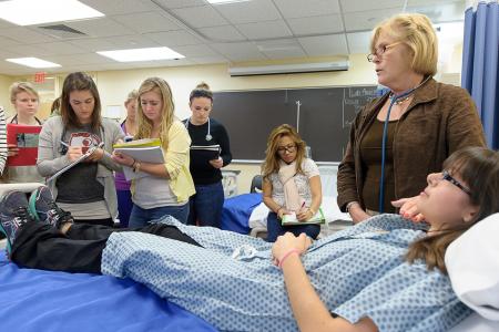 Nursing students examining a mock patient