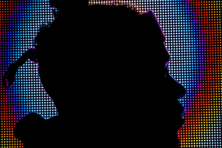 Silhouette of person in front of digital screen