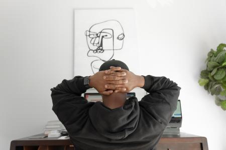 man in gray hoodie sitting on chair - Photo by Keenan Beasley
