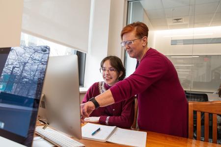 Photo of faculty member assisting student at computer