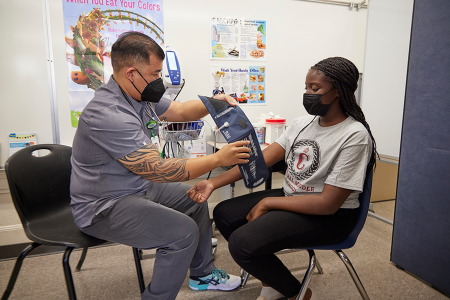 A school nurse preparing to take the blood pressure of a student