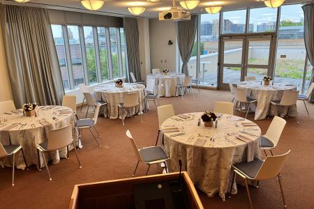 Room C503 setup in banquet style with round tables and a skyline view