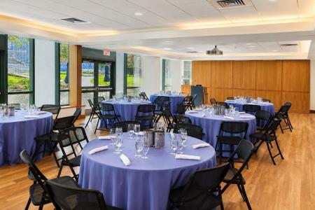 The Kotzen Room set up for a banquet with round tables and a view of the large windows