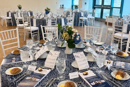 The Kotzen Room set up for a dinner banquet with round tables and a view of the windows