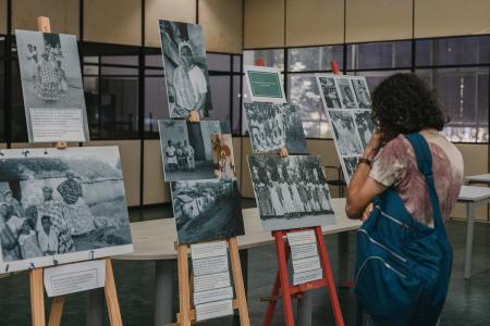 A conference participant viewing the exhibition "In the City of Women" during the BRASA conference at UFBA, Salvador, Brazil, July 2026. 
