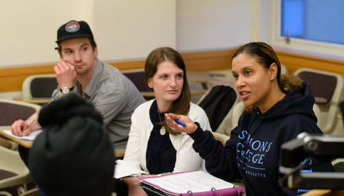 Three graduate students in a classroom at Simmons University
