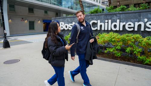 2 Simmons nursing students talking as they walk past the Boston Children's Hospital