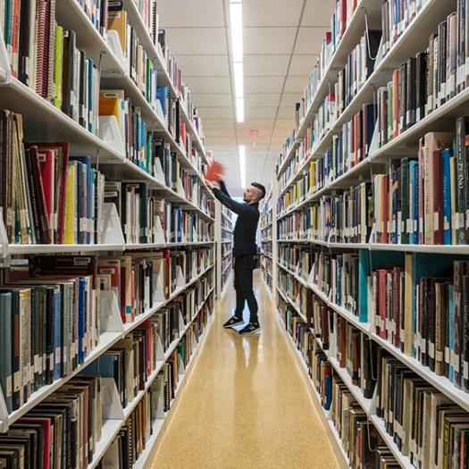 Student standing in the library stacks