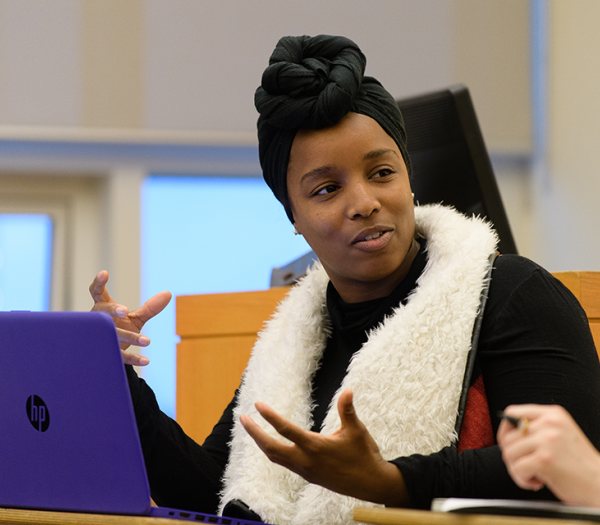 A Simmons student talking to a classmate and gesturing with their hands