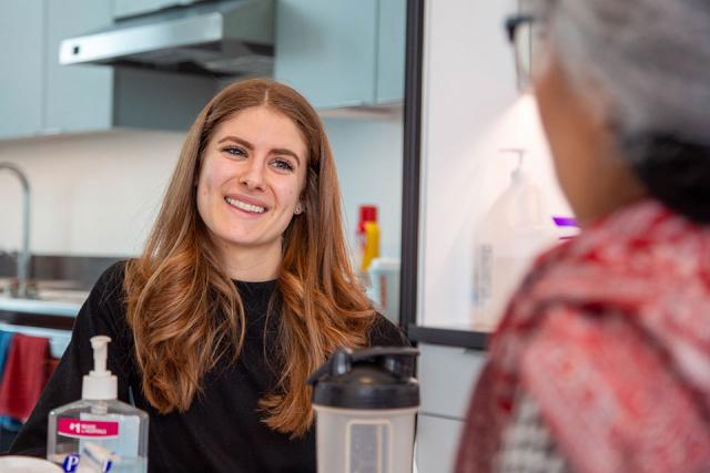 A nutrition student smiling while interacting with another student