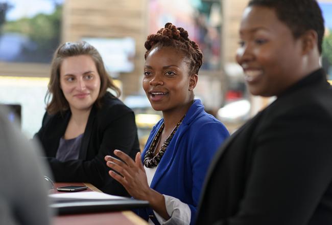Students sitting at a table talking to each other
